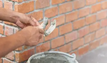 A worker building a brick structure