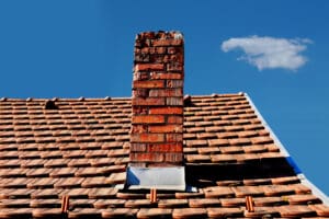 A damaged chimney that has weathered, spalling bricks