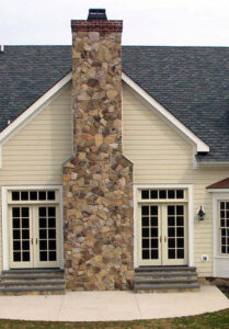 Cultured stone chimney on side of house