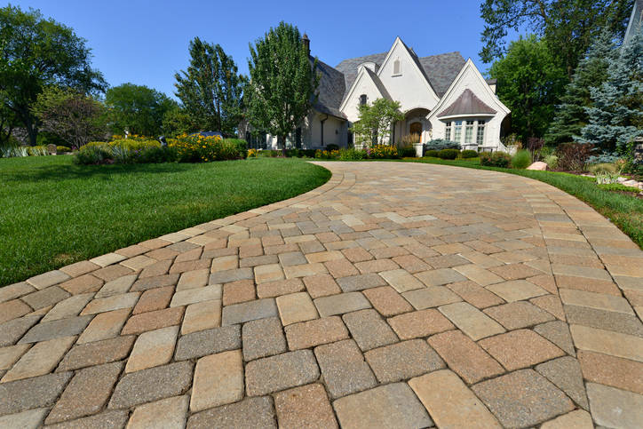 Long brick driveway with white house in distance